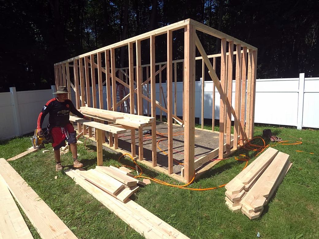 Crew cutting lumber for a shed