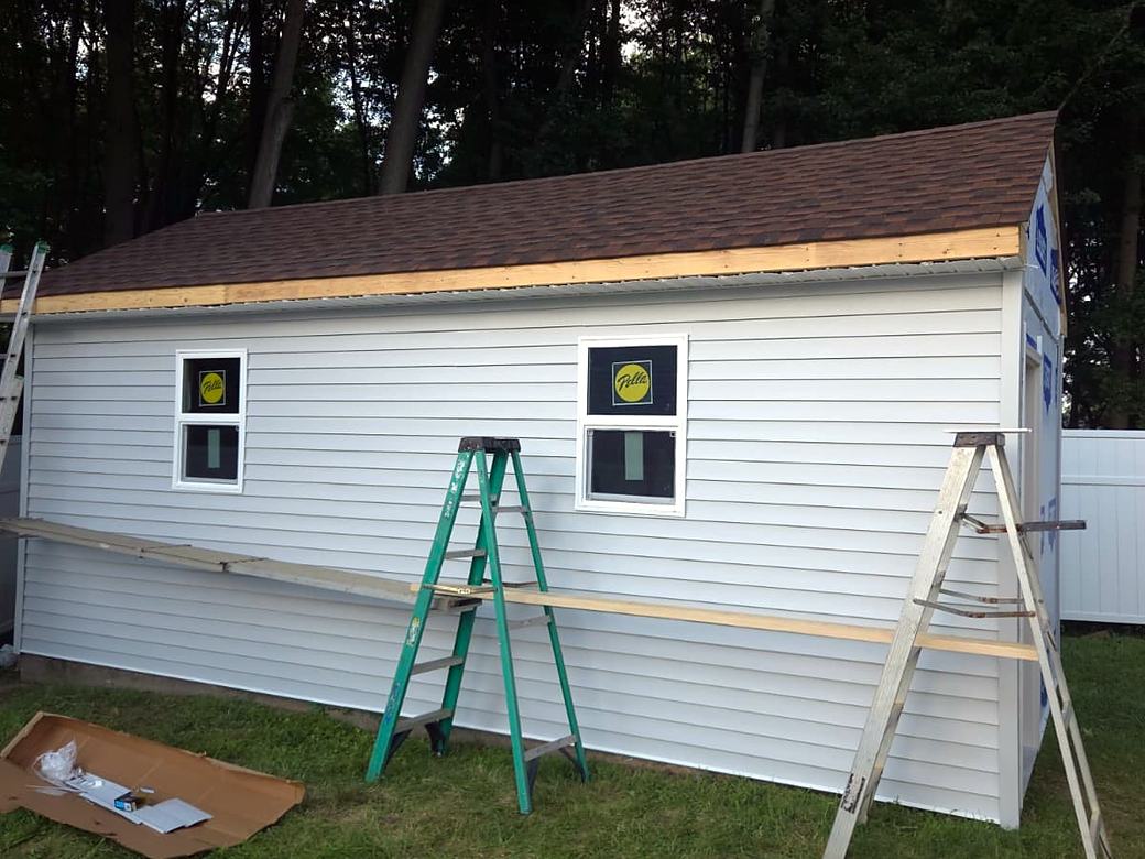 Shed with siding and shingles going on