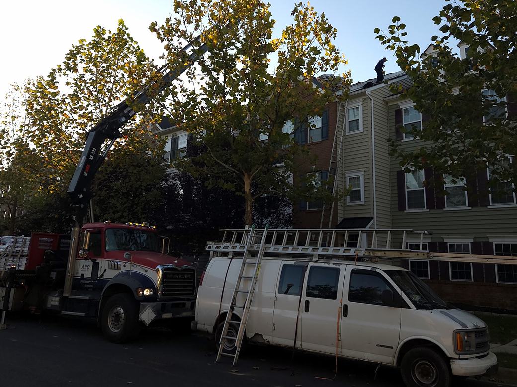 Shingles delivered and ladders up at a townhome roofing job