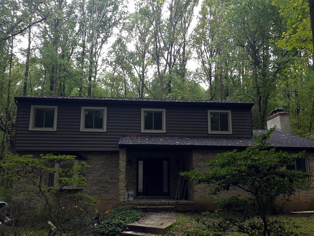 Two story home with new roof shingles and new dark siding